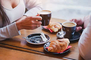 two people having coffee and croissants